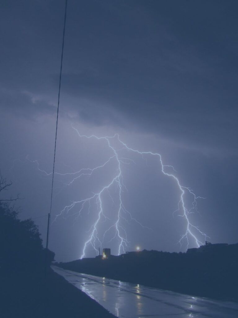 Lighting striking ground at night in distance.