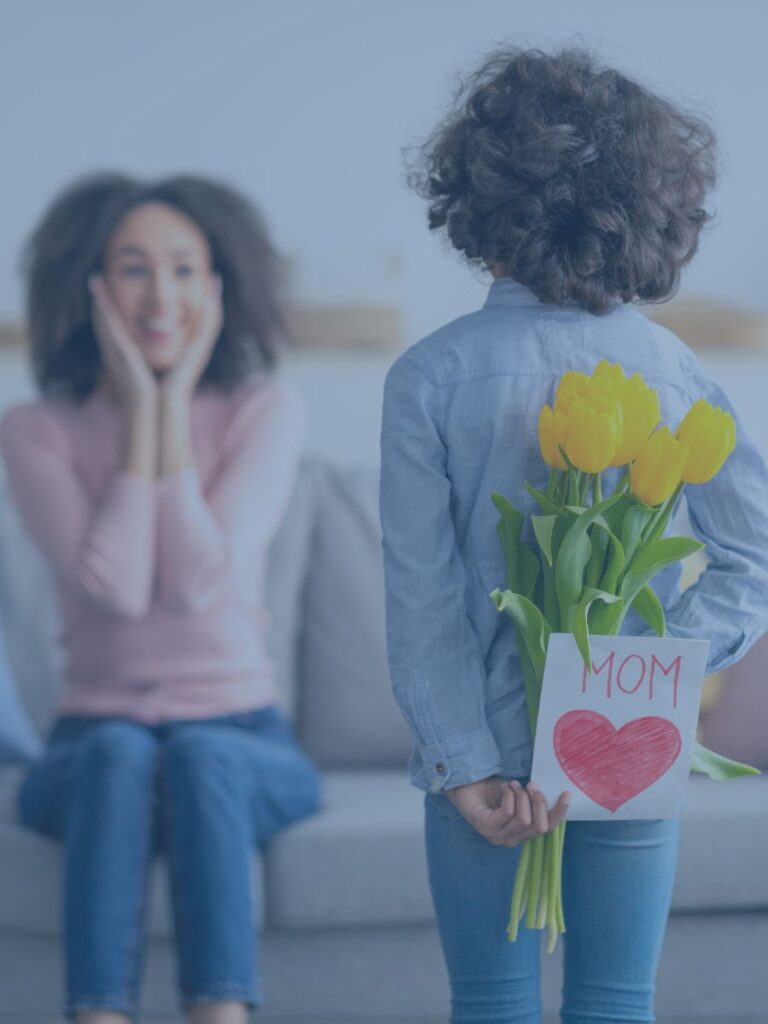Child surprising mom with flowers behind back.